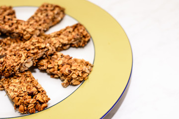 Homemade oat and peanut protein bars on a yellow serving plate, the image has some room for text.