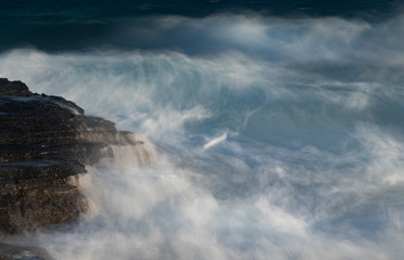 Splashing stormy windy sea waves on a rocky seashore