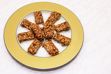Homemade oat and peanut protein bars on a yellow serving plate, the image has some room for text.