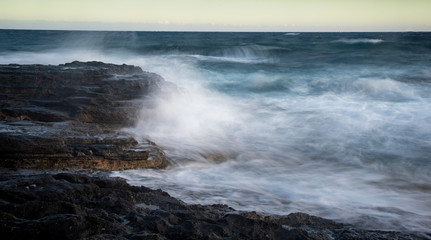 Splashing stormy windy sea waves on a rocky seashore