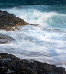 Splashing stormy windy sea waves on a rocky seashore