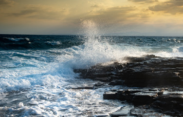 Splashing stormy windy sea waves on a rocky seashore