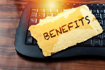benefits concept on carton old card above keyboard