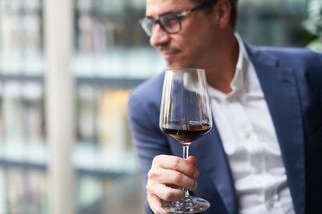 Handsome man tasting red wine at an event.