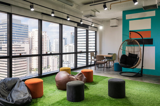 Creative room coworking space with cushions and chairs on artificial grass in office