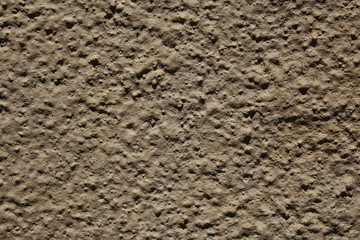 Surface in a beige tone, which is decorated with a mixture of cement.