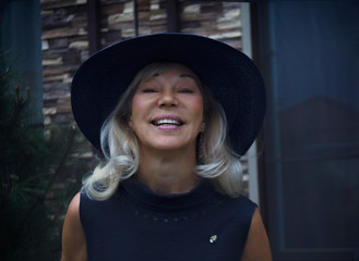 Happy senior stylish elegant woman in hat smiling looking at camera in evening