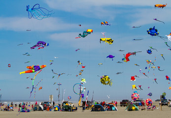 Long Beach, WA;  Many kites in the air and exhibitor's tents on the beach at the Washington State International Kite Festival at Long Beach.  It's the largest kite festival in North America