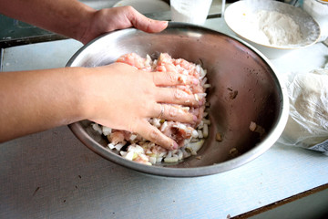 knead the minced meat in a bowl with chopped onions, peppers, close-up