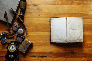 mock up book vintage antique desk accessories of the last century, vintage ink pens on the table with blank postcard, pocket watch, glasses, key. Retro style, top view.