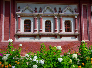 Fototapeta na wymiar Elegant bright flower bed against the background of the brick wall .