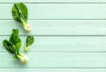 Bok choy on green wooden table top view copy space