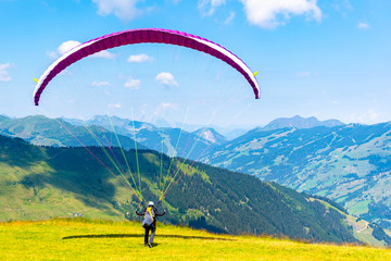 Paraglide launching. Starting procedure of paraglider on high mountain meadow. Recreational and competitive adventure sport