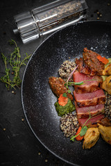 Grilled tuna fish. In a dark plate on a dark concrete table
