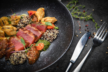 Grilled tuna fish. In a dark plate on a dark concrete table
