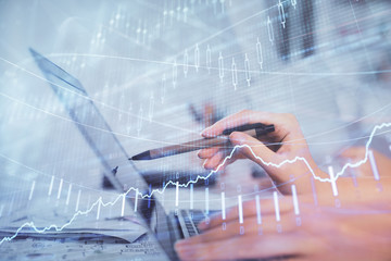 Multi exposure of woman hands typing on computer and financial graph hologram drawing. Stock market analysis concept.
