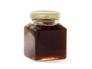 Jar of black forest honey isolated on white