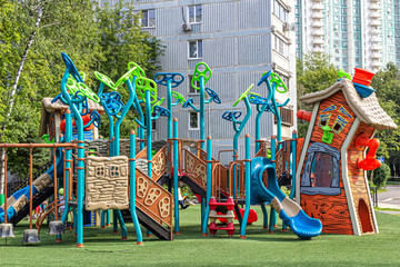 Children's town on the playground with fairy-tale houses, ladders and slides
