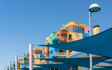 Very colourful buildings shot through tarpaulins in the marina at Albufeira Portugal