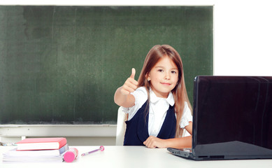 Happy and cute teen school girl sitting on laptop