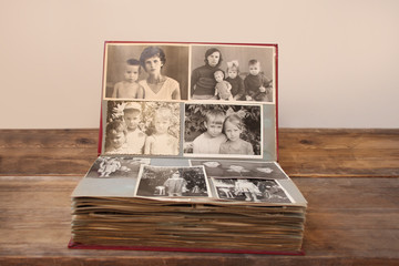 old retro album with vintage monochrome photographs in sepia color, the concept of genealogy, the memory of ancestors, family ties, childhood memories - obrazy, fototapety, plakaty