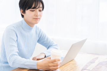 部屋でラップトップコンピューターを見る女性