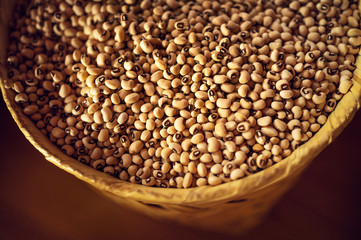 Exotic colorful mexican beans on wicker basket. Top view of legumes. Concept of beans food. Exotic beans on wooden table. Rustic background of beans. Colorful legumes on rustic setting.