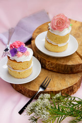 Mini cake with little roses on a wood table 