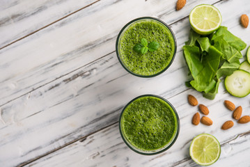 Spinach and almond smoothies against white wooden background. Concept of healthy food, eating, and lifestyle.