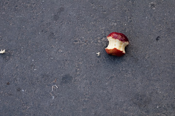 Bitten apple thrown on the ground