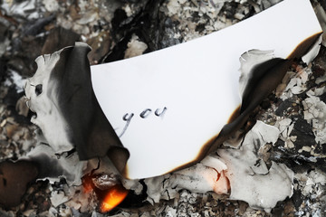 Burning word You on paper.
