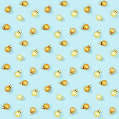 Seamless regular creative pattern with gloden shiny small Christmas balls on blue paper.