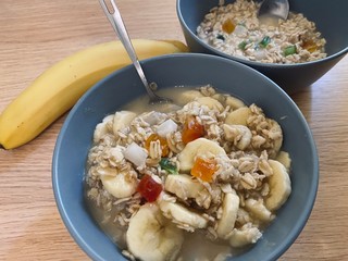The oatmeal with fruits and banana on the table