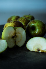 Damaged green apples on a wooden table 