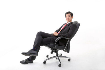 Asian young Chinese man wearing formal business office ware on white background sitting on office chair relax think success happy worried