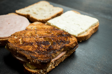 Fresh sandwich with jam and cheese on a dark wooden table 