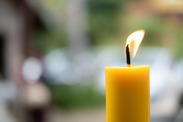 Light flame candle burning brightly on blurred background