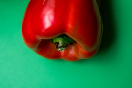 red bell fresh pepper on a green surface 
