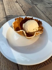 Tasty ice-cream is on the white plate on the table