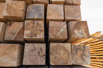 Raw wood beam, stacked at construction site. Wood texture, background. Wooden planks, lining, boards for construction works in the sawmill. Timber mill.