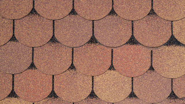 Roof grainy bituminous coating for the rooftop with a pattern in the form of scaly tiles in beige and brown colors with a black outline. Industrial construction background for design.