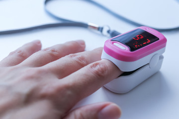 Hand with a portable pulse oximeter on the finger
