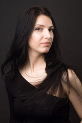 Fototapeta premium A brunette girl in black dress with with long straight hair