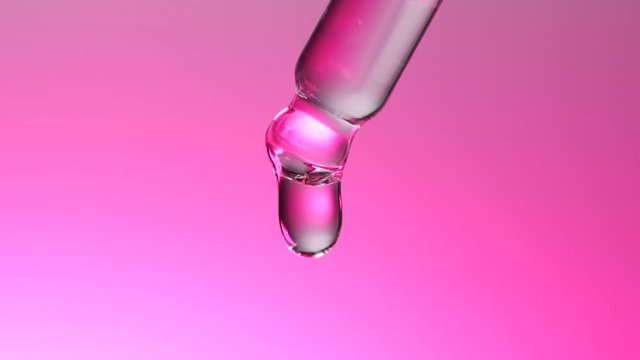 Water dropper in slow motion on pink background
