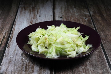 Fried and stirred sliced fresh cabbage with sugar and soy sauce on the plate. Famous vegetarian side dish menu in Asia restaurant. Healthy and low fat food. 