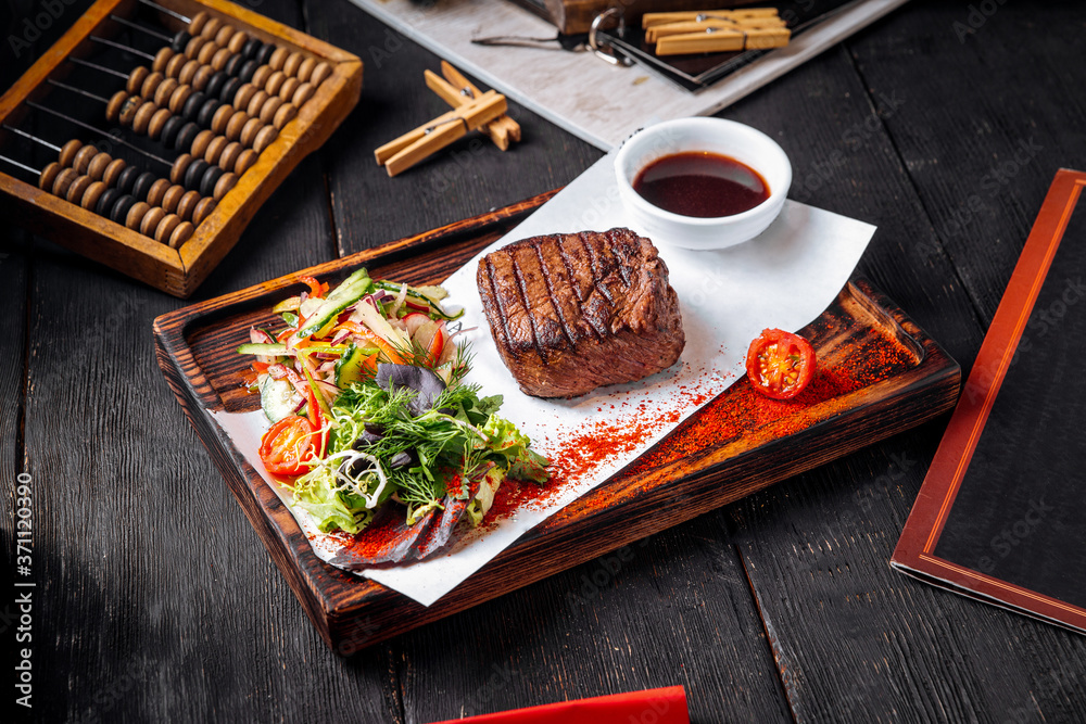 Wall mural fillet mignon steak on board with salad and sauce