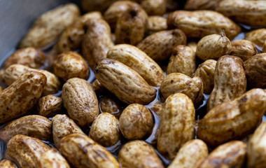 fresh groundnuts in the water on the pot preparing for boiling. 
peanut texture by close - up taken. top view monkey nut photography.