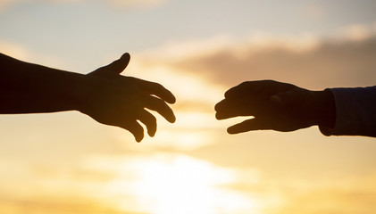 Outstretched hands, salvation, help silhouette, concept of help. Giving a helping hand. Rescue, helping gesture or hands.