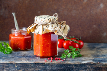 Tomato sauce in a glass jar and ingredients, close-up, horizontal. Copy space