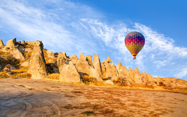 Naklejka na ściany i meble Hot air balloon flying over spectacular Cappadocia